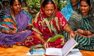 Vrouwen van Omm Sairam tonen het groepskasboek en de individuele boekjes, op de stapel links (foto: Opmeer Reports)