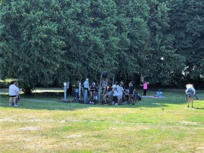 Kinderen hangen op de fitnessapparaten op het tennisveld Nellestein